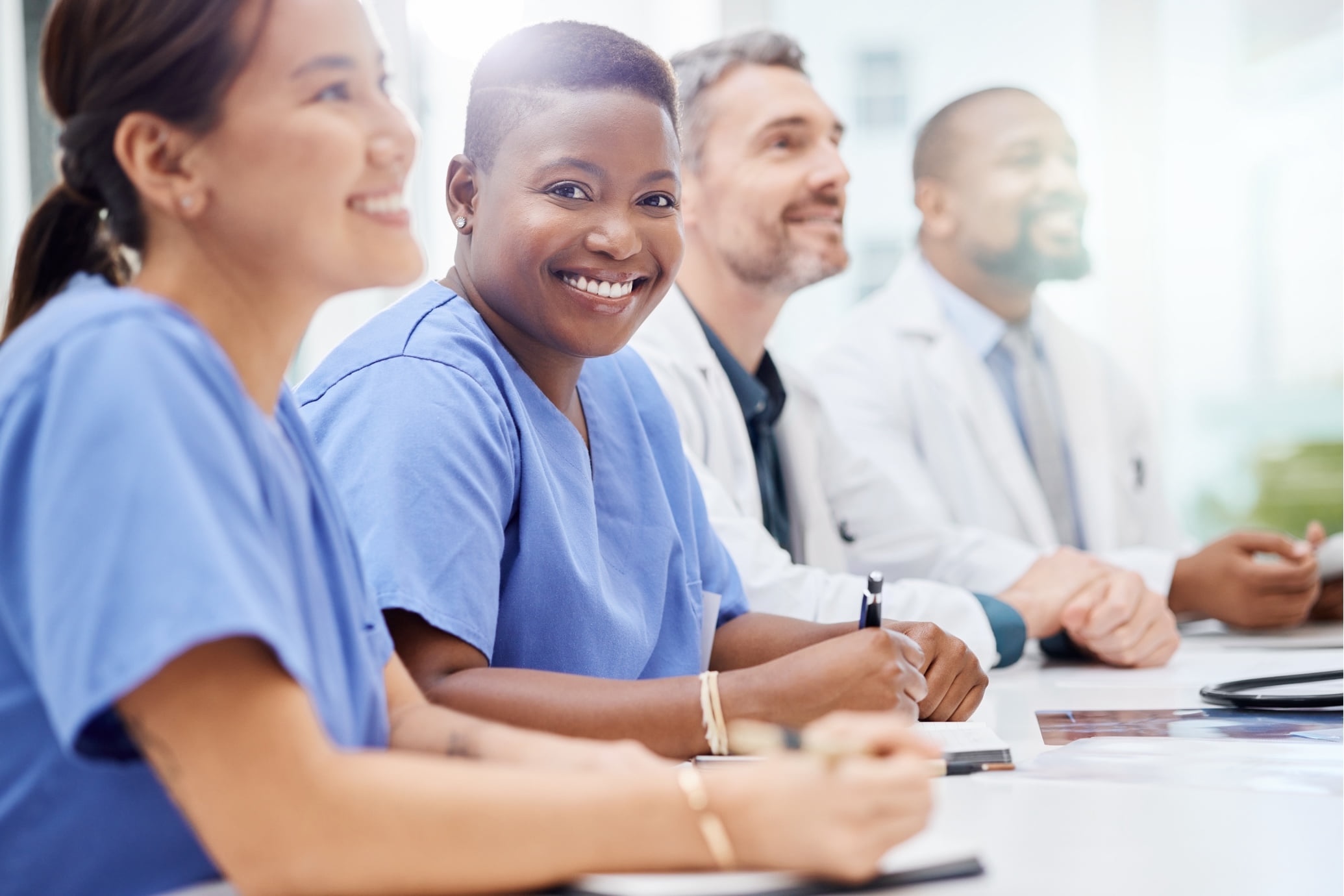 Group of doctors in a meeting listening and taking notes
