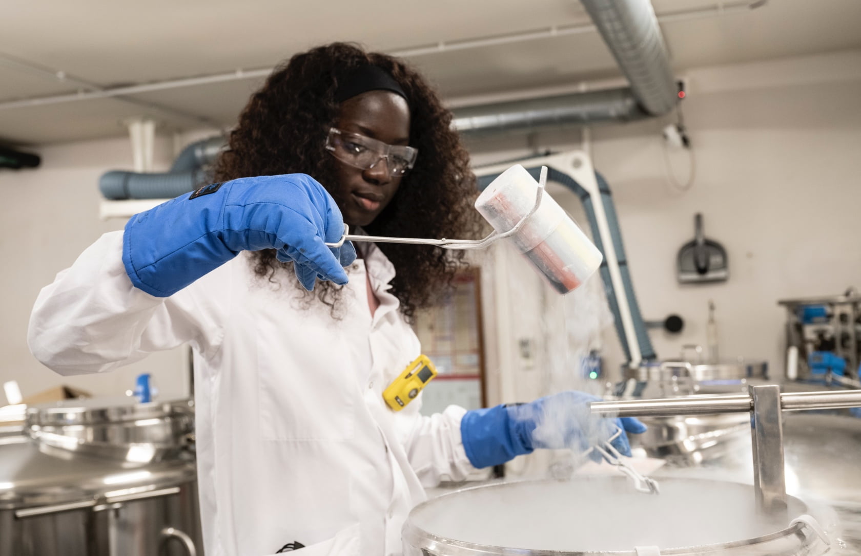 Female scientist in the laboratory taking out samples from liquid nitrogen